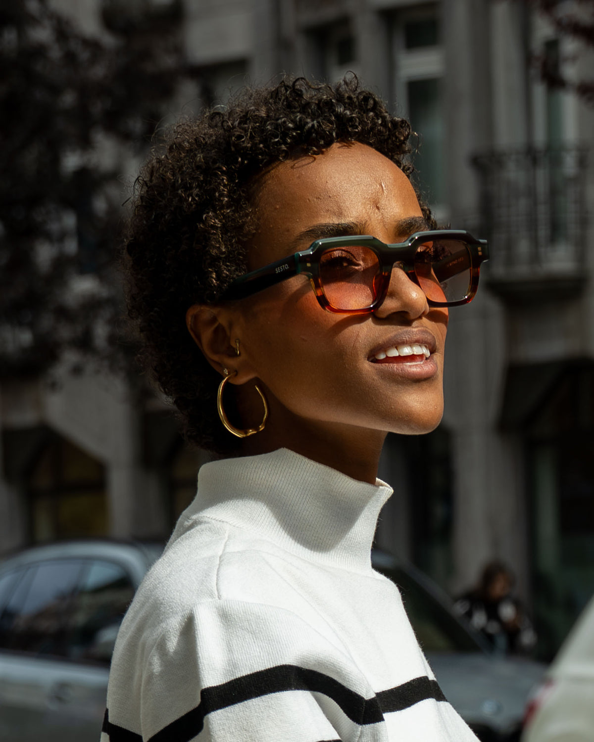 Nahaufnahme einer Frau mit eckiger SESTO. Sonnenbrille in der Stadt